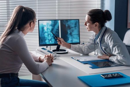 Doctor checking a patient's x-ray of spine